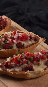 Mexican Molletes with refried beans, melted cheese, chorizo, and fresh pico de gallo