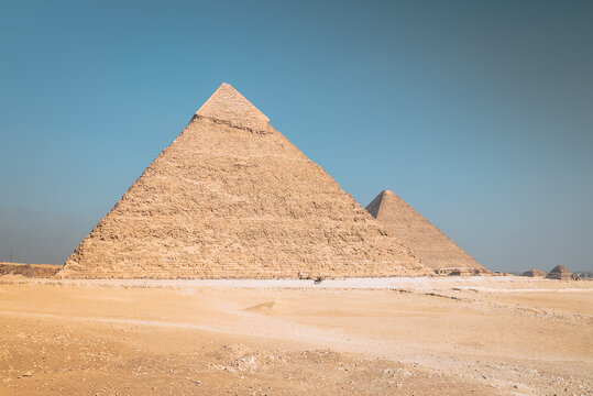 View of Giza Necropolis with the Great Pyramid of Giza and the Pyramid of Khafre under a clear blue sky in Al Haram, Giza Governorate, Egypt.