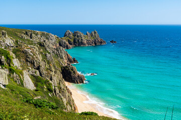 Fototapeta premium Turquoise waters and rugged cliffs along a picturesque coastal beach. Cornwall, UK. 