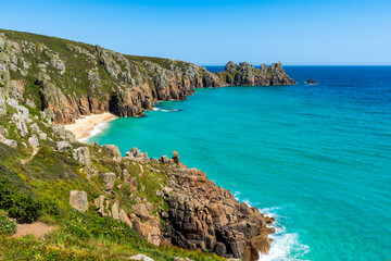 Fototapeta premium Turquoise waters and rugged cliffs along a picturesque coastal beach. Cornwall, UK. 