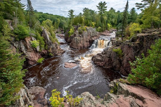 Powerful Wisconsin Waterfall Cascading Over Moss-Covered Rocks Amidst a Lush Forested Landscape