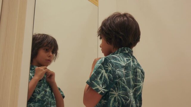 Young boy in fitting room trying on a new shirt