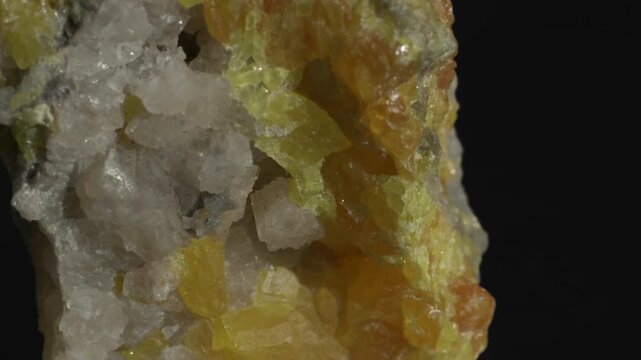 Yellow fluorite crystals in calcite matrix isolated on a black background