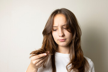 Obraz premium Young woman concerned about hair loss holding hairbrush