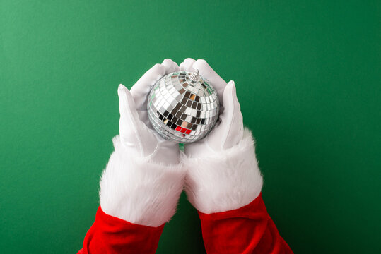Merry Christmas and happy New Year from Santa Claus holding a sparkling disco ornament
