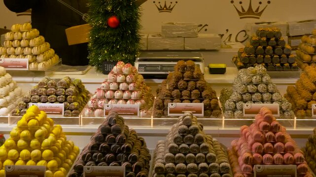 Chocolate truffles display at christmas market stall. Elegant and abundant display of gourmet chocolate truffles and sweets arranged in pyramids, on sale at a festive christmas market stall