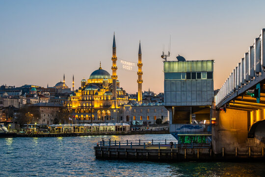 Illuminated New Mosque and Galata Bridge over Golden Horn at dusk in Istanbul, Turkey