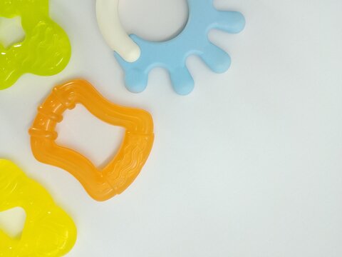 colorful baby teether toys flat lay with copy space on white