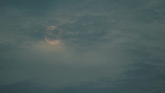 The moon covered with Moving thin clouds

