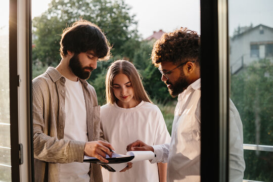Realtor consulting clients viewing real estate contract