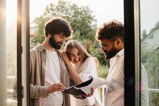 Realtor helping happy couple signing real estate documents