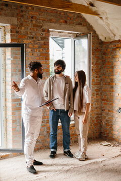Real estate agent showing new home to happy couple