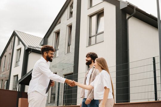 Realtor shaking hands with clients after property deal