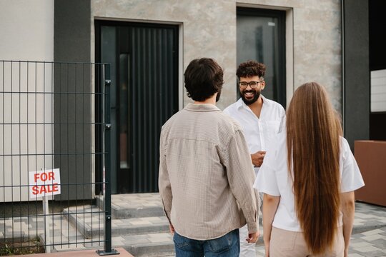 Realtor discussing new home purchase with young couple