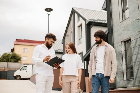 Realtor discussing new house purchase with young couple