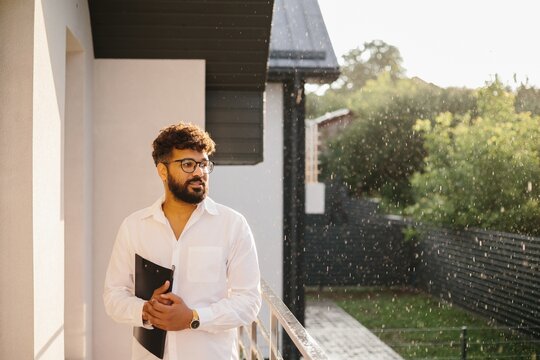 Male realtor holding clipboard looking at property