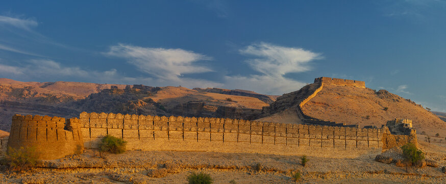 View of the historic Ranikot Fort with its stone fortifications and bastions stretching across the arid landscape under a clear blue sky in Karchat, Sindh, Pakistan.