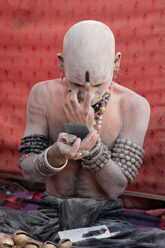 Lahore, Punjab, Pakistan - 31 March 2008: View of a devotee at the Urs of Madhu Lal Hussain applying ash and a mark to his forehead while looking into a small mirror.