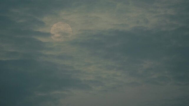 The moon covered with Moving thin clouds

