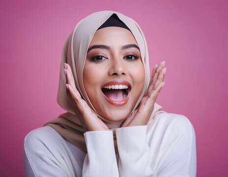Joyful Young Muslim Woman with Hands on Face Expressing Amazing Surprise