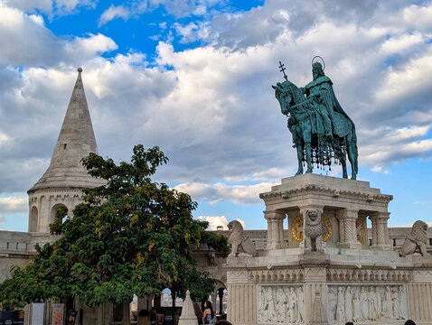 Equestrian statue of Saint Stephen I at Fisherman's Bastion, framed by Neo-Romanesque towers under dramatic clouds, Castle Hill, Budapest, Hungary.