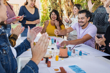 Obraz premium large group of latin people in painting classes in a terrace outdoors in Mexico Latin America, multi generational Hispanic and diverse team meeting in art classes 