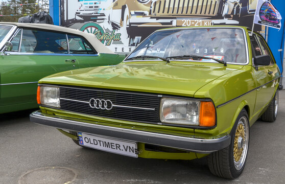 Vibrant lime green 1978 Audi 80 B1 featuring sharp geometric lines, rectangular headlights, and custom golden deep dish wheels. Сlassic European car culture cornerstone