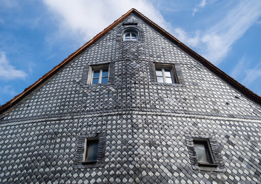 Furth, Germany - 15 July 2026: View of a historic slate-tiled building facade in the old town of Furth, featuring diamond-patterned masonry and small windows under a blue sky.
