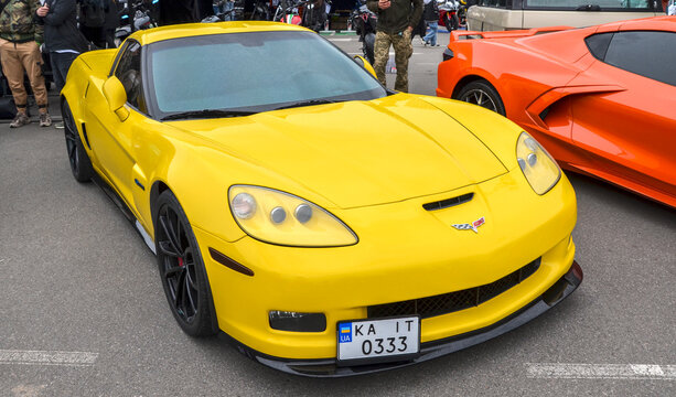 Yellow Chevrolet Corvette C6 Z06 with aggressive wide stance functional hood scoop, and sleek headlights. American supercar icon from the golden era of analog sports cars