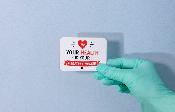 Your Health Is Your Greatest Wealth Motivational Medical Quote on Card Held by Healthcare Professional.