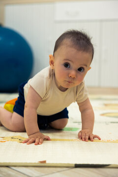 Curious baby crawling on playmat discovering new surroundings