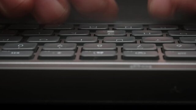 Close-up macro timelapse male hands typing rapidly on keyboard with subtle motion blur, camera smoothly slides parallel to keys. Dynamic footage of remote work, business activity and digital workflow