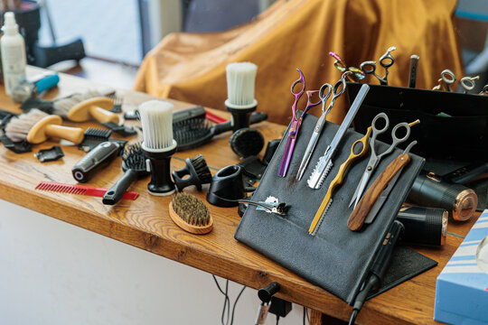 Barber Tools and Haircut Accessories On Wooden Counter in Modern Barbershop Mirror