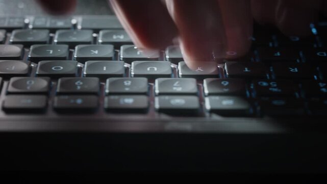 Close-up timelapse male hands typing rapidly on keyboard with motion blur, camera smoothly slides parallel to keys. Dynamic footage of remote work, business activity and digital workflow at night