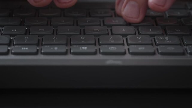 Close-up male hands typing on black keyboard, cinematic shot camera smoothly slides parallel to keys. Detailed footage of remote work, business communication, productivity and modern digital workflow