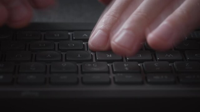 Close-up macro timelapse male hands typing rapidly on keyboard with subtle motion blur, camera smoothly slides parallel to keys. Dynamic footage of remote work, business activity and digital workflow