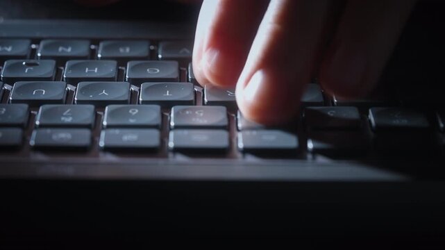 Close-up timelapse male hands typing rapidly on keyboard with motion blur, camera smoothly slides parallel to keys. Dynamic footage of remote work, business activity and digital workflow at night