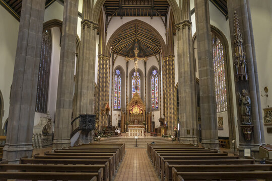 Birmingham, United Kingdom - 20 July 2026: View of St Chad's Cathedral interior, featuring tall stone columns, ornate stained glass windows, and a central altar with a crucifix.