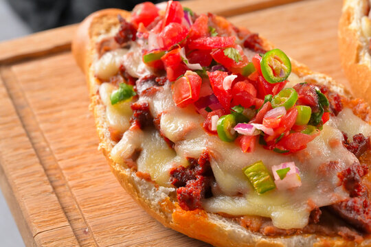 Delicious Mexican mollete with melted cheese, chorizo sausage, diced tomatoes, onions and jalapeño peppers