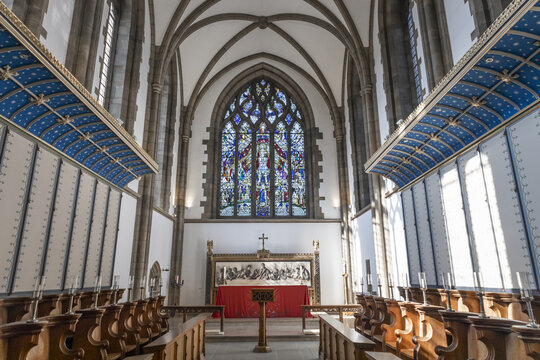Sheffield, England, United Kingdom - 15 July 2026: View of the interior of Sheffield Cathedral with a stained glass window, altar, and wooden pews under a vaulted ceiling.