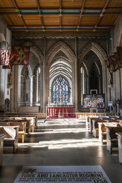 Sheffield, England, United Kingdom - 15 July 2026: View of the interior of Sheffield Cathedral with wooden pews, stone arches, stained glass, and a memorial floor plaque.