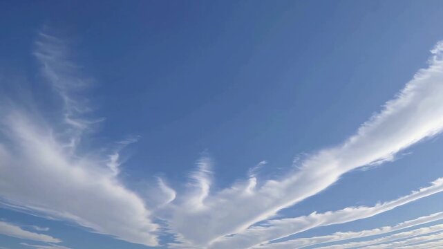 Viewing soft white clouds stretching across bright blue horizons as gentle winds create artistic natural textures while peaceful summer weather showcases beautiful clear day outdoor panorama scenery
