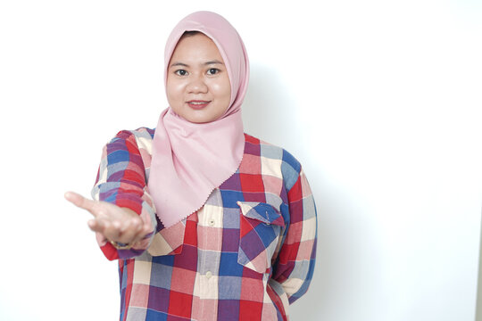 Happy Asian woman with hijab showing open hand gesture for product display isolated on white