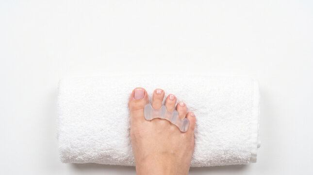 Top view of silicone toe separator on foot resting on towel