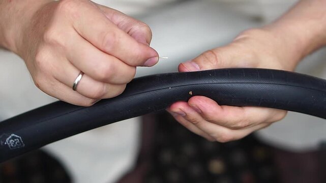Close‑up of man checking bicycle inner tube for puncture