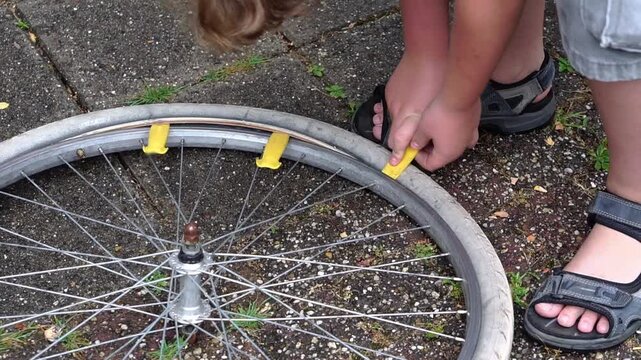 Teenage boy removing bicycle tire with plastic levers