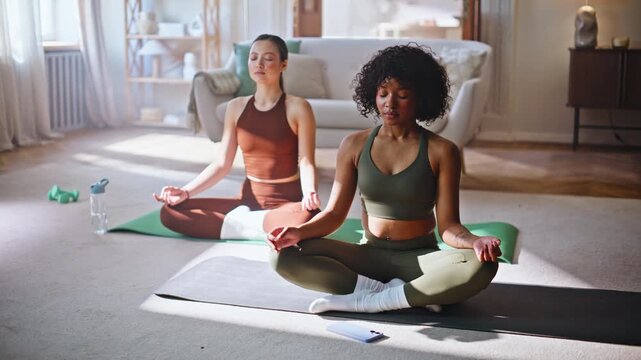 Woman picking up phone during home yoga meditation with calm partner nearby