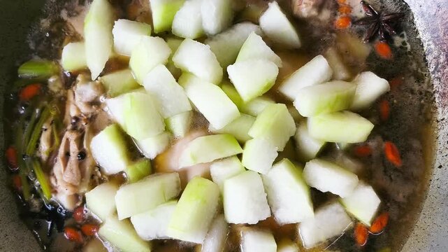 Cooking chicken soup with winter melon in pot, indoor Chiangmai Thailand.