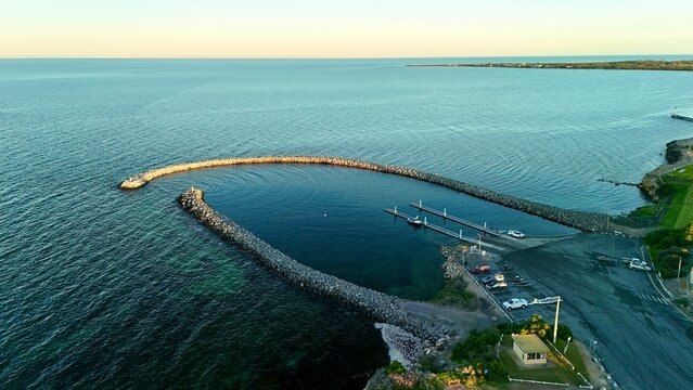 Edithburgh, Yorke Peninsula, South Australia &ndash; 4K aerial drone views of marina, curved breakwater, jetty, coastline, township, Spencer Gulf, coastal houses and residential estates at sunset