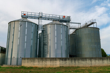 Grain storage silos at agricultural facility, metal cereal silos for wheat and corn, modern farming infrastructure, agribusiness logistics, food supply chain, harvest storage and industrial  © rikstock